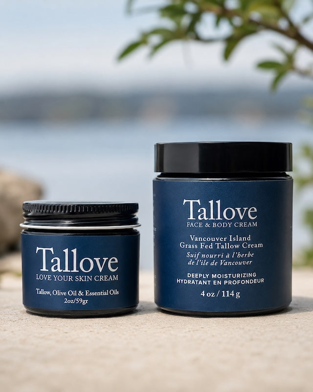 Two blue Tallove skincare jars displayed side by side outdoors, showing the 2 oz Love Your Skin Cream jar and the 4 oz Face & Body Cream jar with clear white labels and black lids against a soft waterfront background.