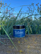 Tallove Face & Body Cream with the sky and plants in background
