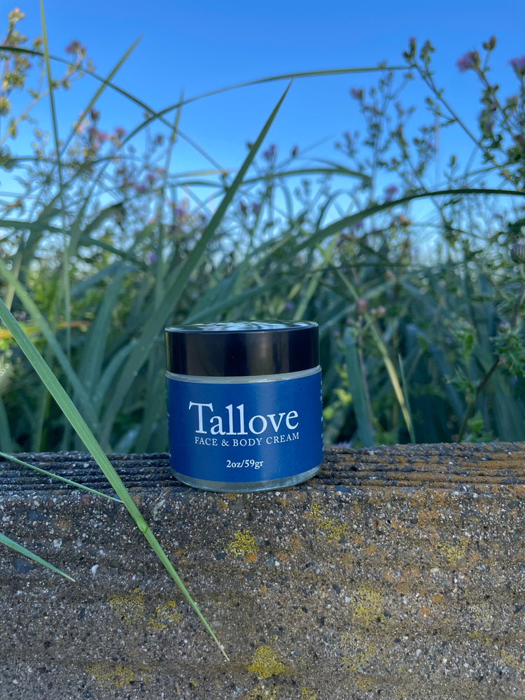 Tallove Face & Body Cream with the sky and plants in background